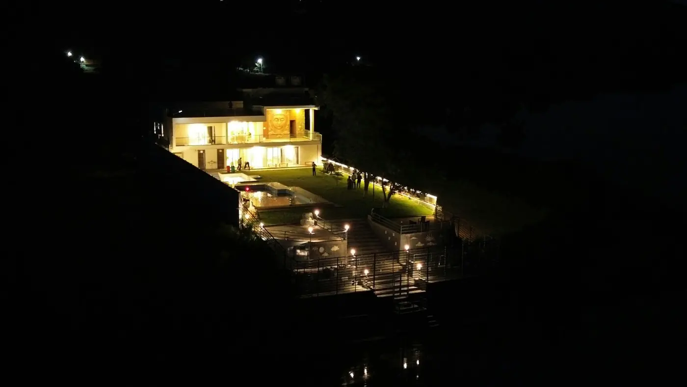 Gece karanlığında yamaçta ışıkları yanan villa