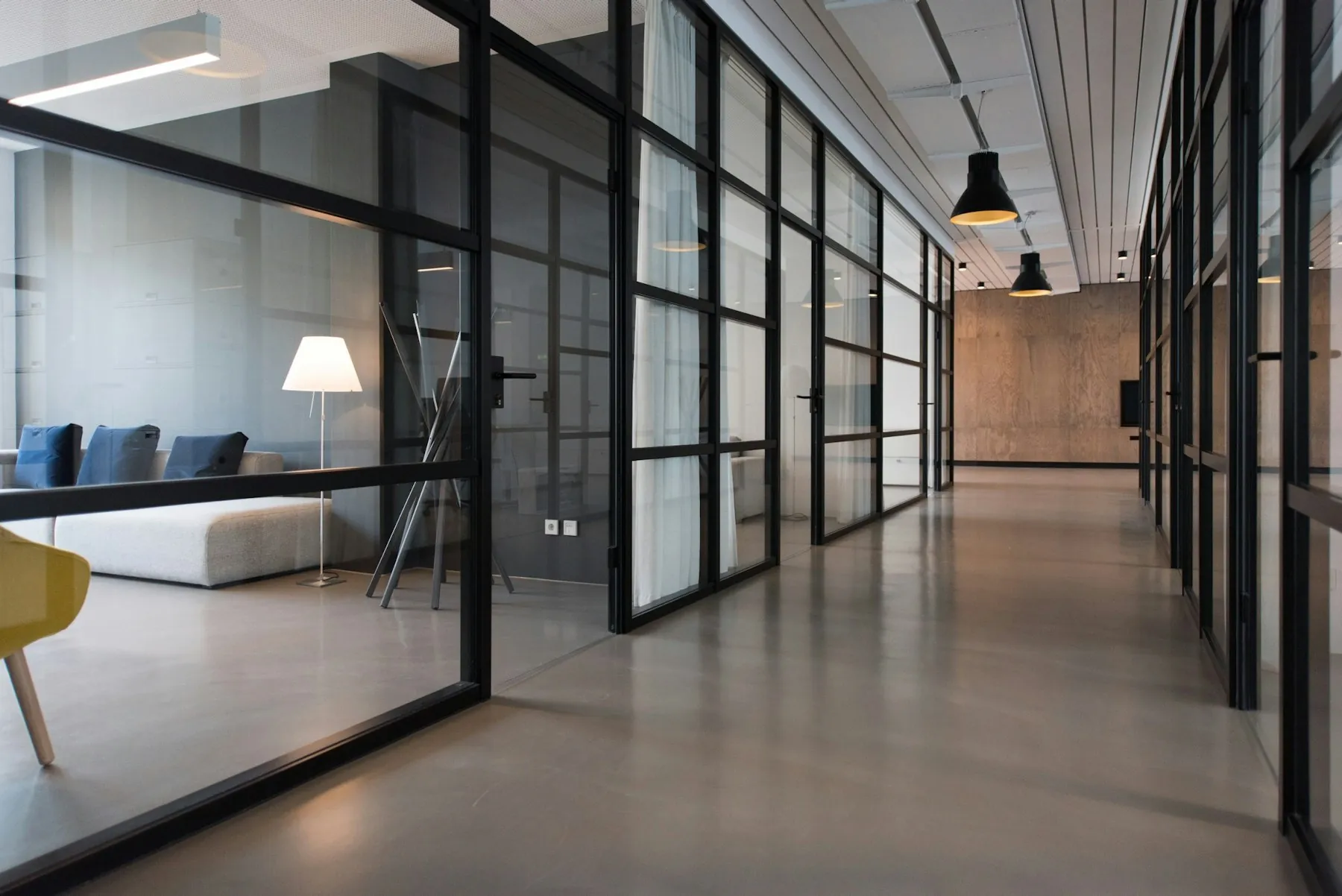 Cam bölmeli, aydınlık bir ofis koridoru